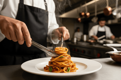 bucatini being plated by a chef with sauce